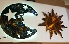 two metal sun and moon wall hangings on a white board with gold foiling