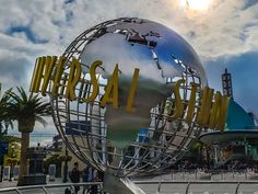 a large metal globe sitting in front of a building