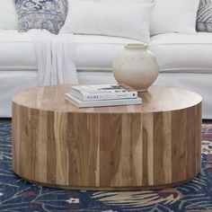 a wooden table sitting on top of a blue rug in front of a white couch