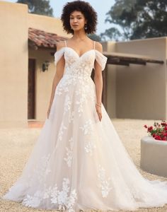 a woman in a wedding dress standing outside