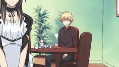 two anime characters sitting at a table in a room with potted plants on the wall