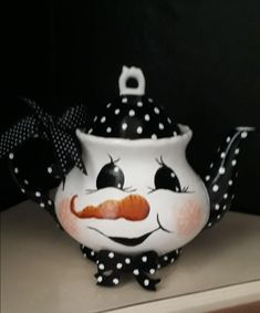 a ceramic teapot with polka dots and a clown nose