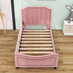 a pink bed frame with wooden slats