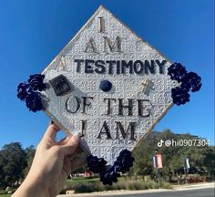 someone holding up a graduation cap that says i am testimony of the team