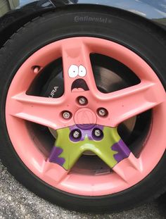 a pink tire with a face painted on it's side and another cartoon character in the center