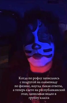 a person wearing a mask with the words in russian on it and an image of a man's face