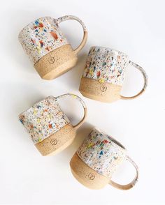 three coffee mugs with sprinkles on them sitting next to each other