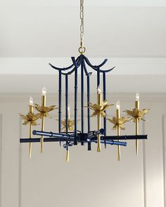 a blue chandelier hanging from the ceiling with gold leaves and candles on it