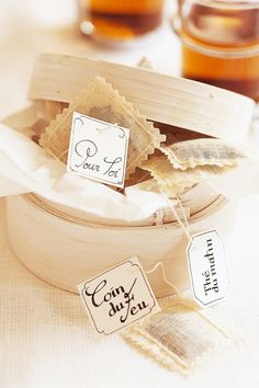 tea bags with labels on them sitting in a wooden container