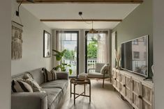 a living room filled with furniture and a flat screen tv on top of a wooden table