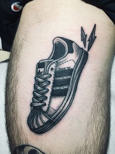 a man's leg with a shoe tattoo on it