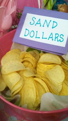 a pink bowl filled with yellow chips and a sign that says sand dollars on it