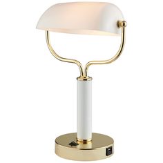 a table lamp with a white shade on the base and a gold plated base
