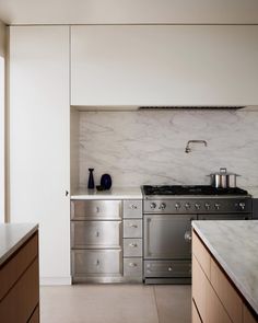 a kitchen with marble counter tops and stainless steel appliances