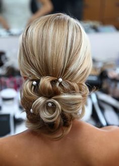 the back of a woman's head with her hair in a low bun