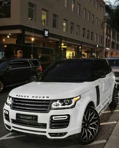 a range rover is parked on the side of the road in front of some cars