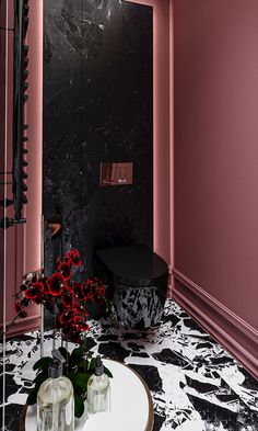 a bathroom with pink walls and marble flooring is pictured in this image, there are two vases on the table