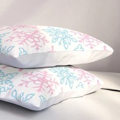 two pillows with pink and blue designs on them