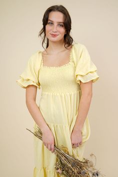 Romantic cottage core inspired smocked bodice dress in loose fit style. This dress comes in a light pastel yellow color that features a square ruffle neckline detailing with a tired ruffle at the sleeves. Flounced tired silhouette with a smocked elastic. Slips on for wear Mother Friendly 100% Cotton Hand Wash Cold / Line Dry Measurements & Fit Notes Model is wearing a Small, Olivia is 5'7, 34-24-35 Pale Yellow Sundress, Lemon Color Dress, Lemon Colour Dress, Pastel Yellow Dress, Pastel Yellow Color, Pale Yellow Dresses, Designer Summer Dresses, Yellow Sundress, Yellow Dress Summer