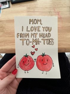 a woman holding up a card with two tomatoes on it that says mom, i love you from my head to - ma - toes