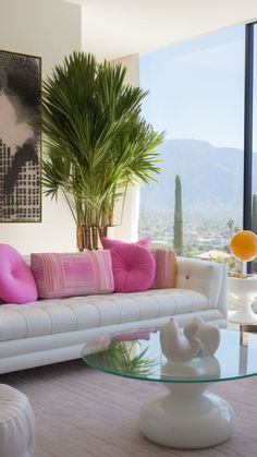 a living room filled with furniture and a large window overlooking the cityscape in the distance