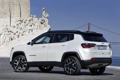 a white jeep parked in front of a monument