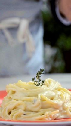 a plate that has some noodles on it with a little sprig of parsley