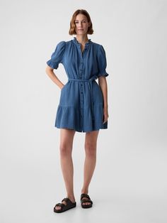 Soft crinkle gauze denim mini dress.  Ruffled crewneck.  Elbow puff sleeves.  Button front.  Braided tie belt at waist.  Tiered skirt.  * Fit: Relaxed.  An A-line silhouette that's easy through the chest with a flared opening.  Hits above the knee.  Model is approx.  5’10” wearing Denim Ruffle Dress, Tiered Mini Dress, Estilo Denim, Denim Mini Dress, Gap Denim, Denim Mini, Tier Skirt, Tiered Skirt, Tie Belt