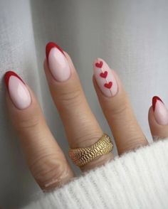 a woman's nails with hearts painted on them