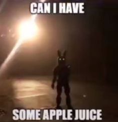 a person in bunny ears standing on the street at night with an apple juice bottle