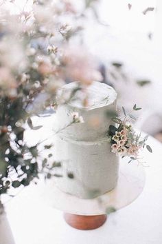 a white cake sitting on top of a table next to a vase filled with flowers