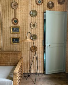 a living room with wicker walls and pictures on the wall, including an open door