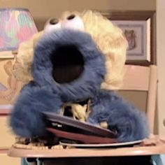 a blue stuffed animal sitting on top of a wooden chair