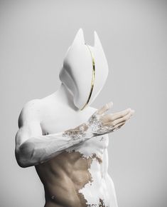 a man with white paint all over his body and hands in front of him, wearing a hoodie