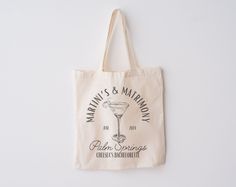 a tote bag hanging on the wall with a martini and matrony logo