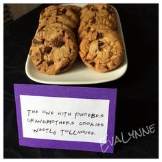 two chocolate chip cookies on a plate with a note