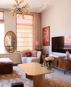 a living room filled with furniture and a flat screen tv on top of a wooden table