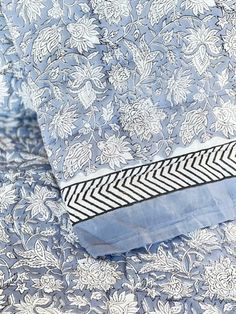a blue and white floral print fabric with an arrow on the side, close up