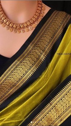 a woman wearing a yellow and black sari with gold jewelry on her neckline