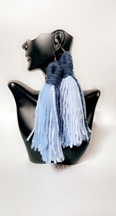 a black mannequin head with blue and white tassels