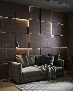 a couch sitting in front of a wall with wooden paneling on top of it