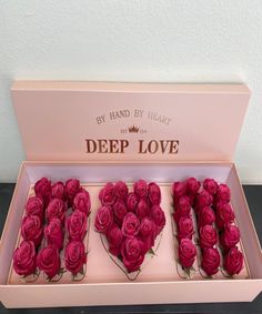 three pink roses in a box with the words deep love written on it and placed inside