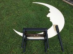 the moon has been made into a chair with two legs, and it is sitting in the grass