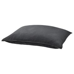 a black pillow sitting on top of a white wall