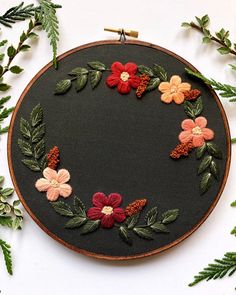 an embroidery project with flowers and leaves on it