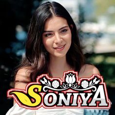 a woman with long hair is smiling and posing for the camera in front of a sign that says soniya