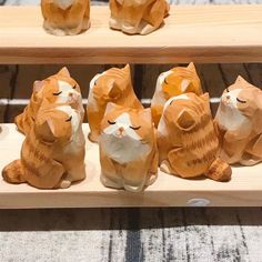 several wooden cats sitting on top of a shelf