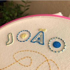 a close up of a cross stitch on a piece of cloth with the word joy