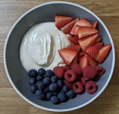 berries, yogurt and blueberries in a bowl on a table