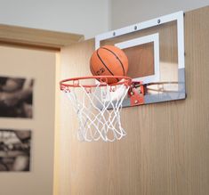 a basketball that is in the hoop with it's net attached to the wall
